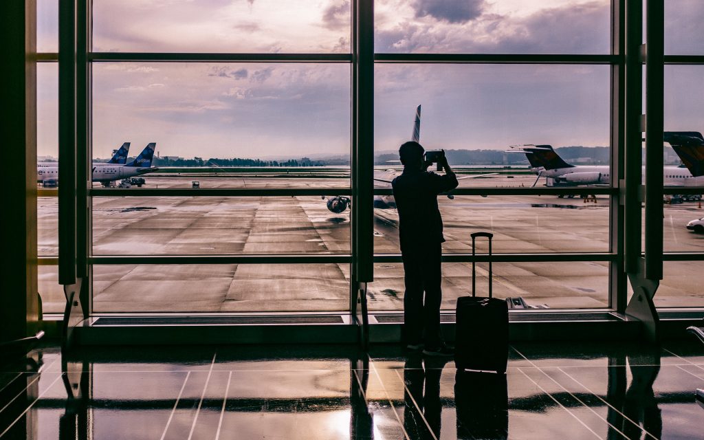 Man Looking Out the Airport Window Carrying Portable Electronic Gadgets for Travelers Philippines 2022