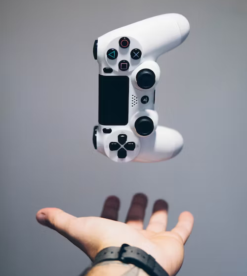 white playstation controller to use in a game console floating above a hand