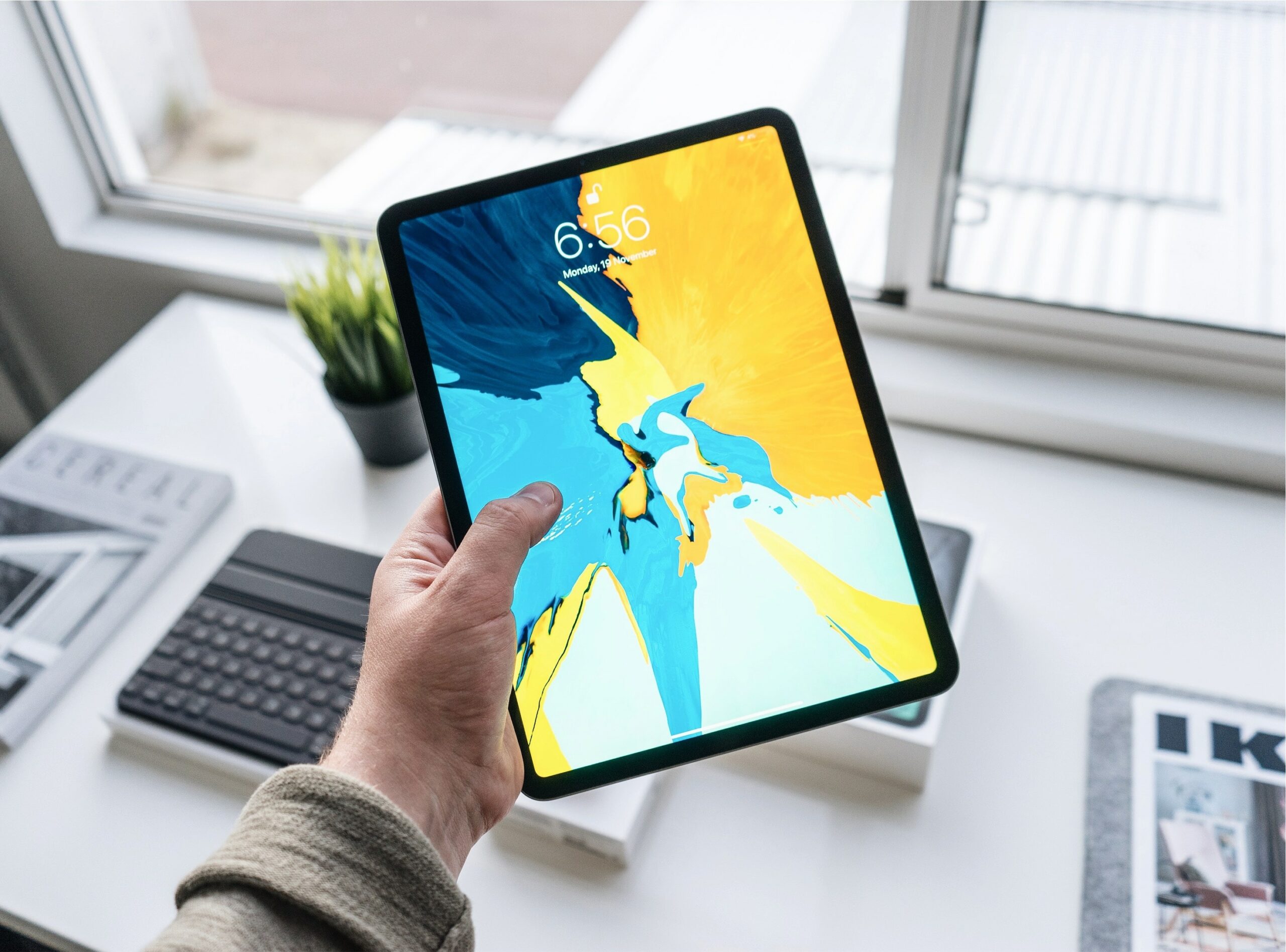 man holding an ipad tablet with blue and yellow screen